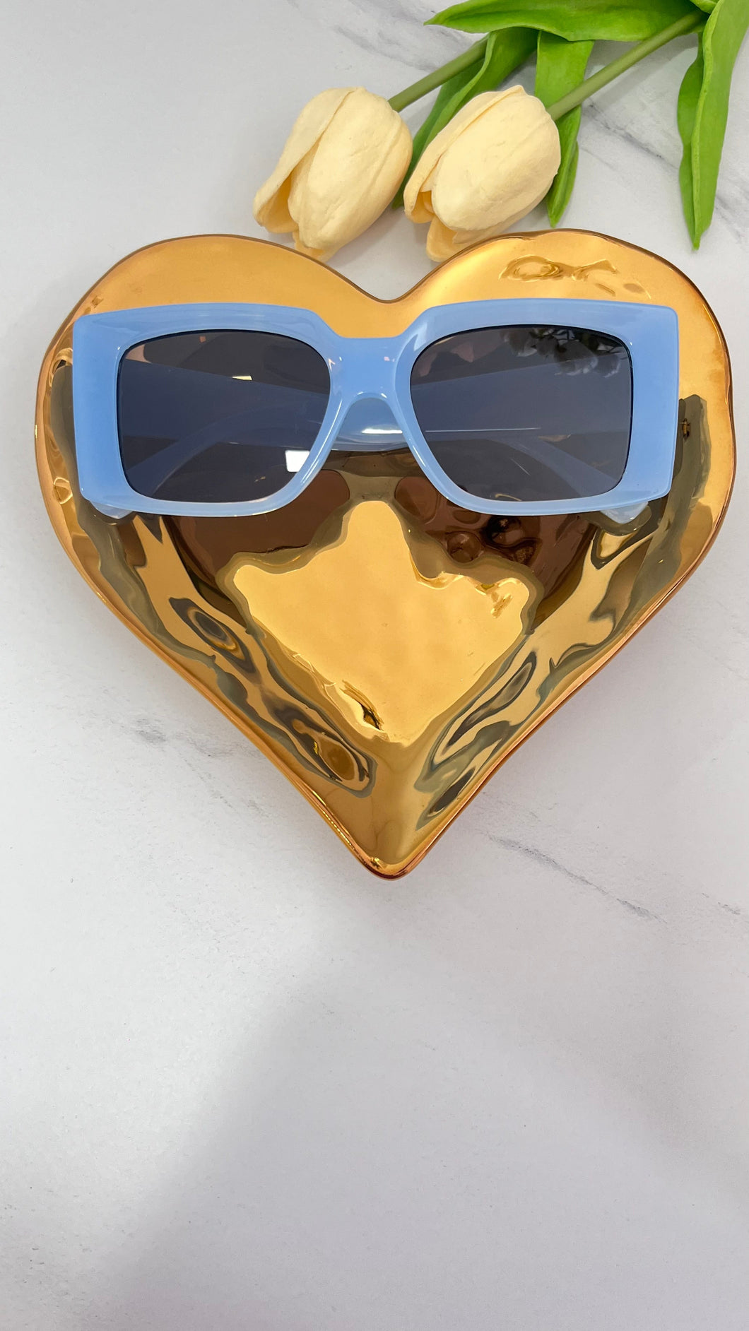 Baby Blue MT sunnies stylishly displayed on a golden heart-shaped plate, accentuating quality jewelry vibes.
