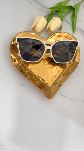 Beige MT Sunnies displayed on a golden heart tray with fresh tulips, showcasing quality jewelry accessories.