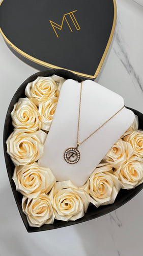18K gold plated initial pendant necklace displayed on a white stand inside a heart-shaped box of cream roses.