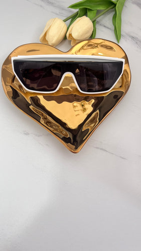 Designer inspired eyewear displayed on a gold heart-shaped plate, showcasing quality jewelry accessories.