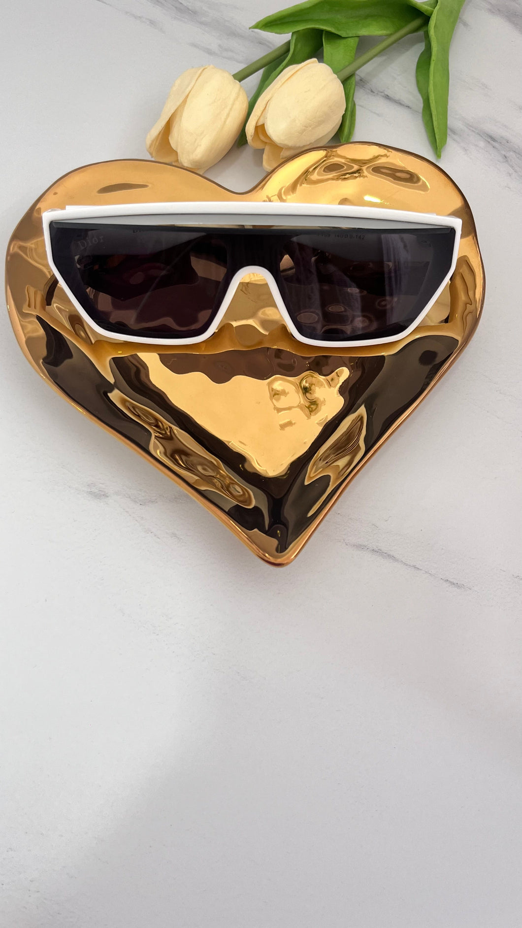 Designer inspired eyewear displayed on a gold heart-shaped plate, showcasing quality jewelry accessories.