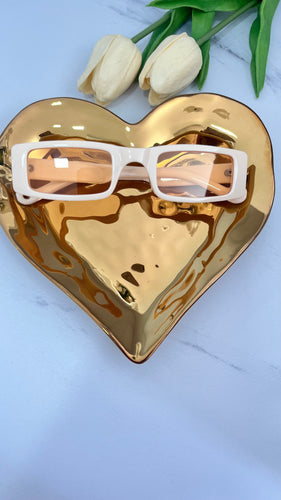 Anna MT Sunnies displayed on a gold heart-shaped dish, showcasing quality jewelry in stylish eyewear.